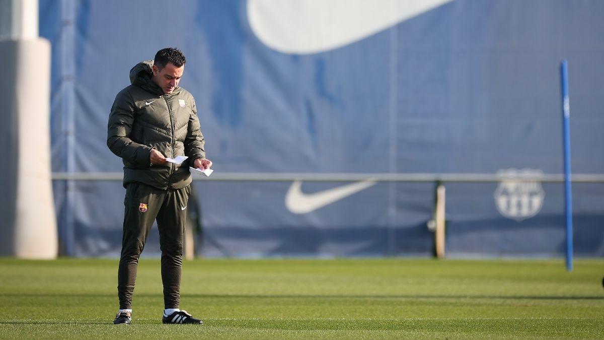 Xavi mira un papel antes del entrenamiento de este sábado