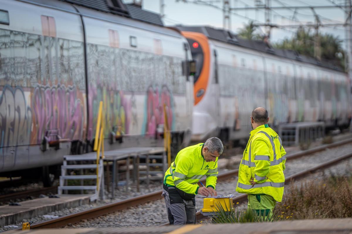 Personal del administrador de infraestructuras, Adif, trabajan junto al trazado de la línea R1 de Rodalies del Maresme.