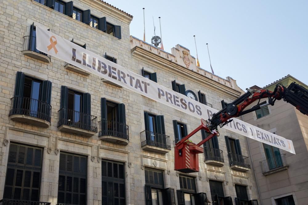 Pengen la pancarta en suport dels presos davant de l'Ajuntament de Girona