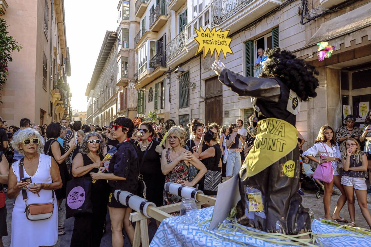 Vecinos de la Calatrava y Canamunt, muchos vestidos de verde y con ramas de árboles, se unen durante sus cercavilas para homenajear a los bellasombras talados en la plaza Llorenç Villalonga.