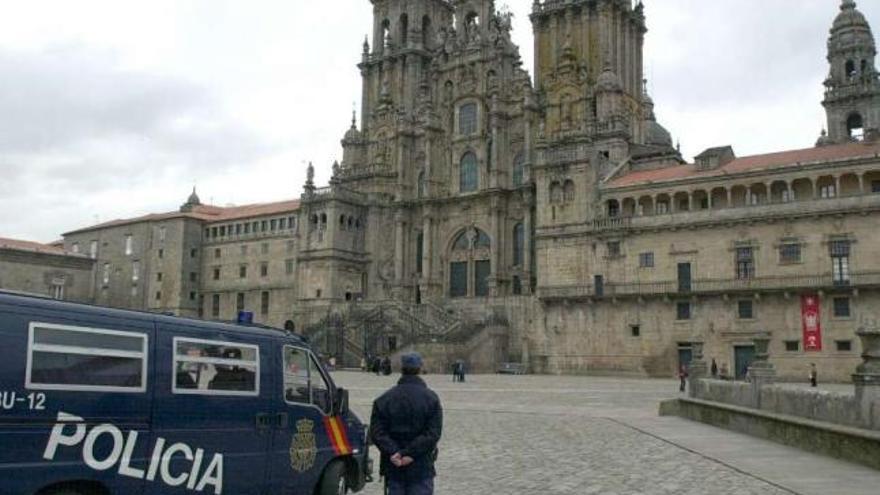 Tres agentes de la Policía Nacional vigilan el acceso a la Praza do Obradoiro. / lavandeira jr