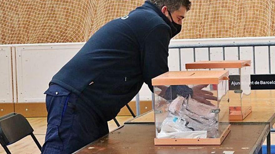 Un operari col·loca les urnes en una mesa de Barcelona