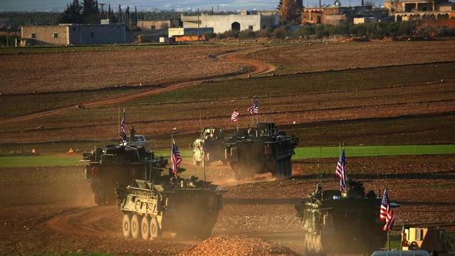 Un convoy de tanques con bande ra de EEUU circulan a las afueras de la ciudad de Manbij, al norte de Siria.