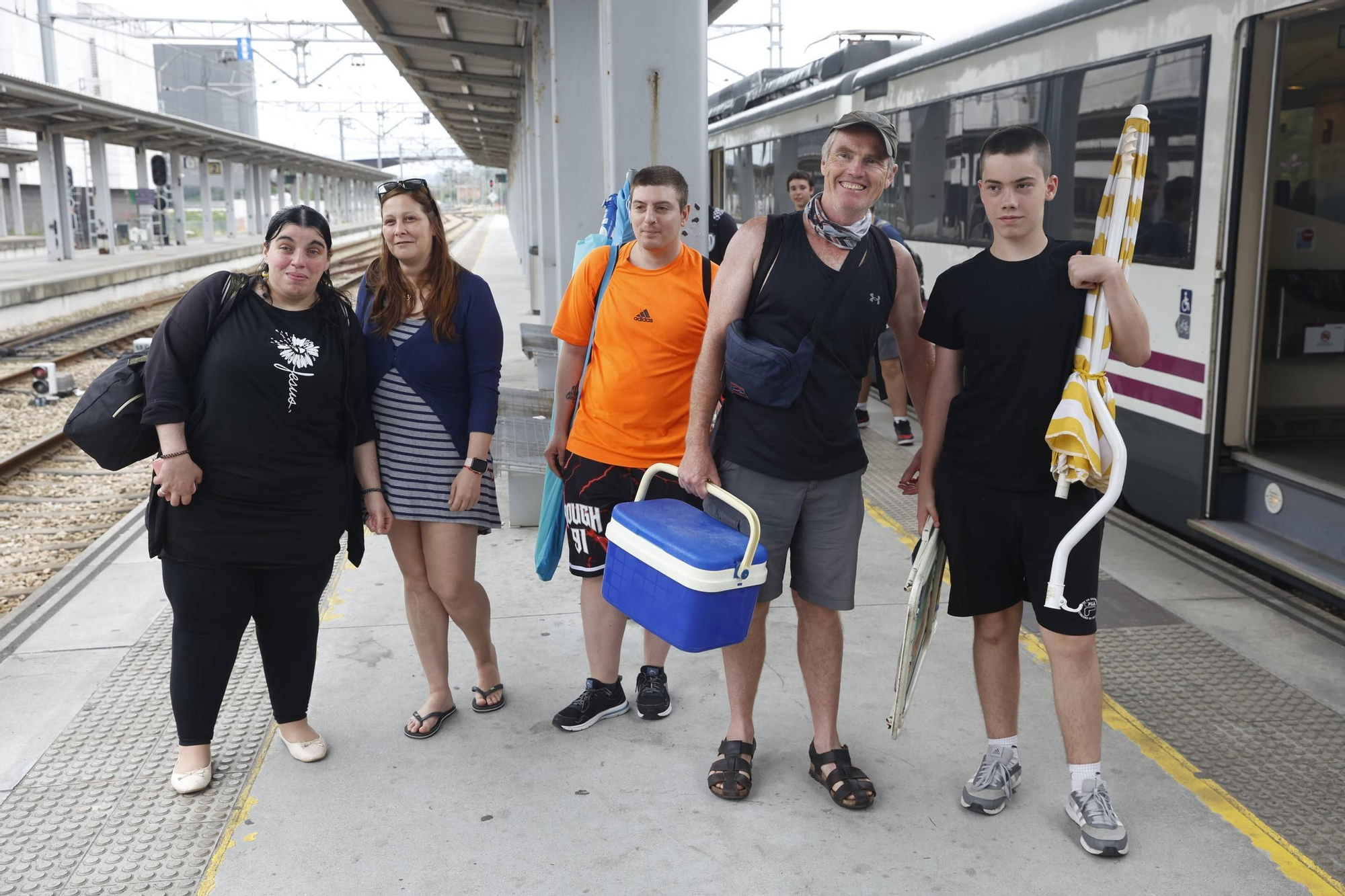 León estrena el tren playero para sofocar la ola de calor: "Siempre venimos a la playa a Gijón" (en imágenes)