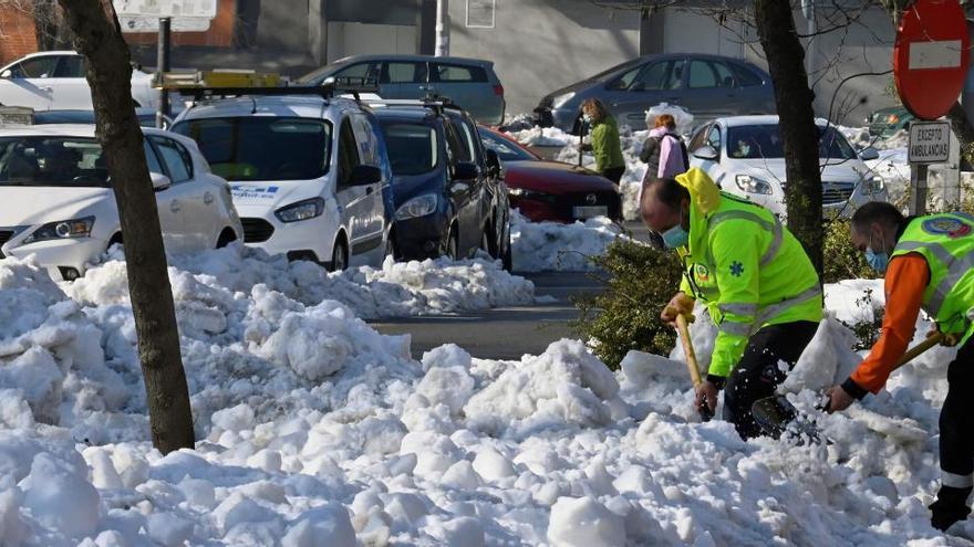 Operaris traient la neu dels carrers de Madrid