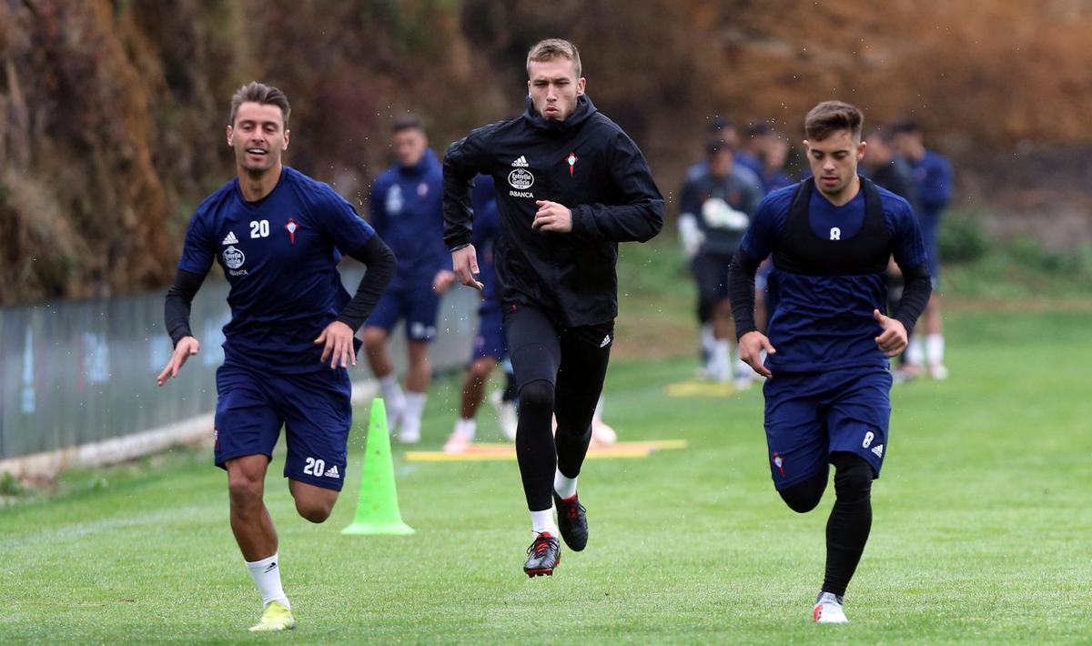 Kevin Vázquez, Rubén Blanco y Fran Beltrán trotan sobre el césped de A Madroa en un entrenamiento  en 2021. | MARTA G. BREA