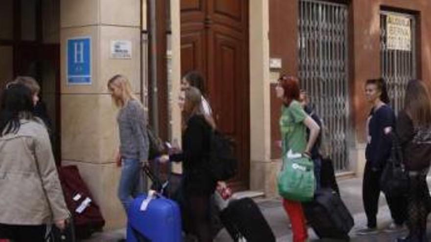 Un grupo de turistas jóvenes en la puerta de un hostal cercano a la Catedral.