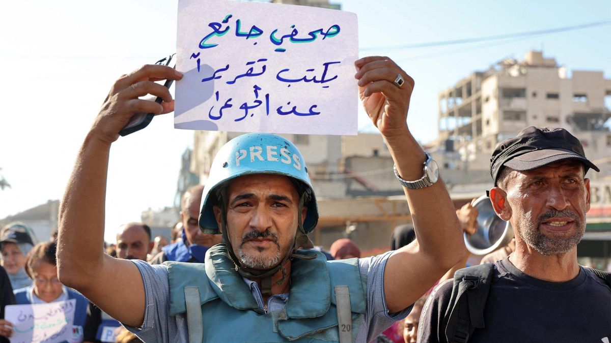 Un manifestante sostiene un cartel con el mensaje en árabe: "un periodista hambriento escribe un reportaje sobre los hambrientos", durante una protesta de periodistas contra el hambre en el barrio de Rimal, en la ciudad de Gaza, el 19 de julio de 2025