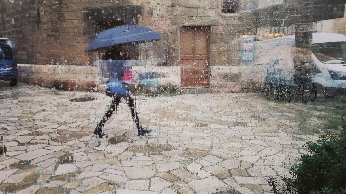 Una mujer pasea por el centro de Palma con un paraguas.