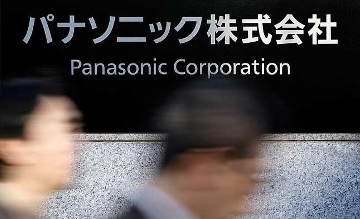Persones caminen davant de logo de Panasonic en les seves oficines de Tòquio (Japó), el dia que la companyia electrònica ha informat la supressió de 40.000 llocs de treball en els pròxims dos anys.