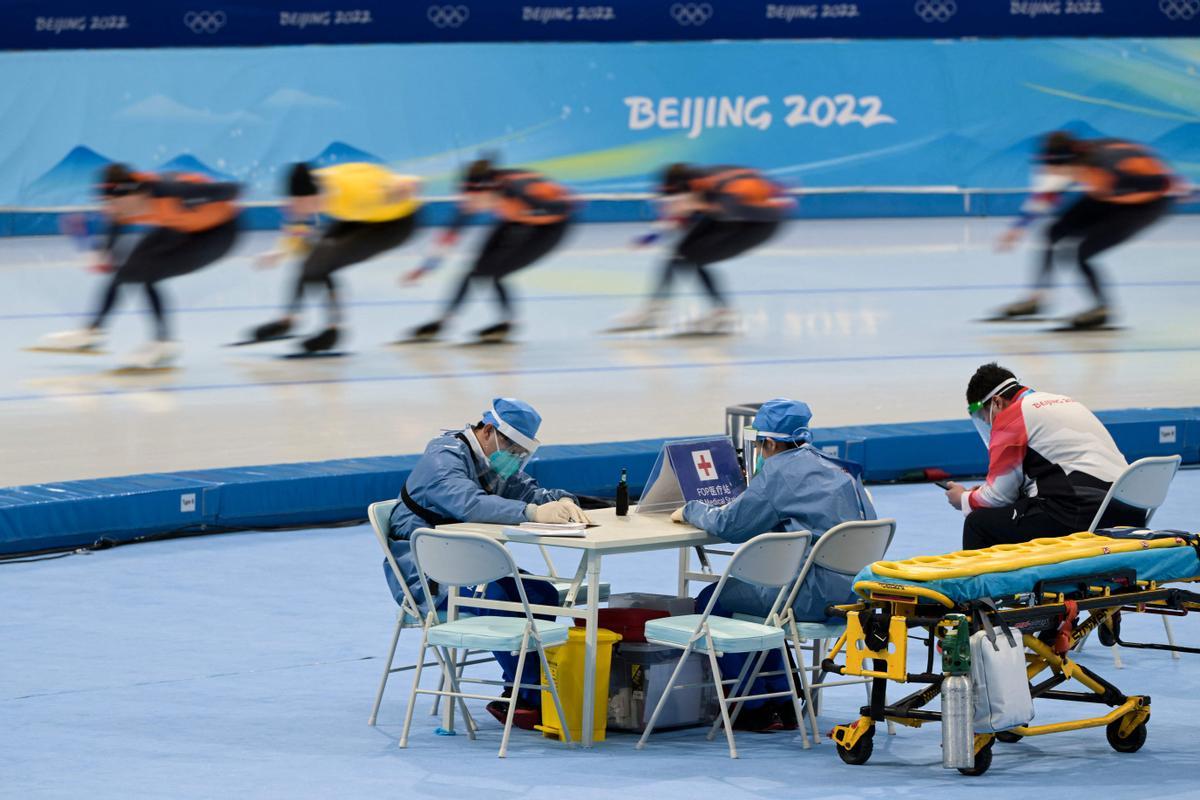 Miembros del equipo médico vistiendo trajes de protección contra el coronavirus, durante un entrenamiento de patinaje en las instalaciones de Pekín.