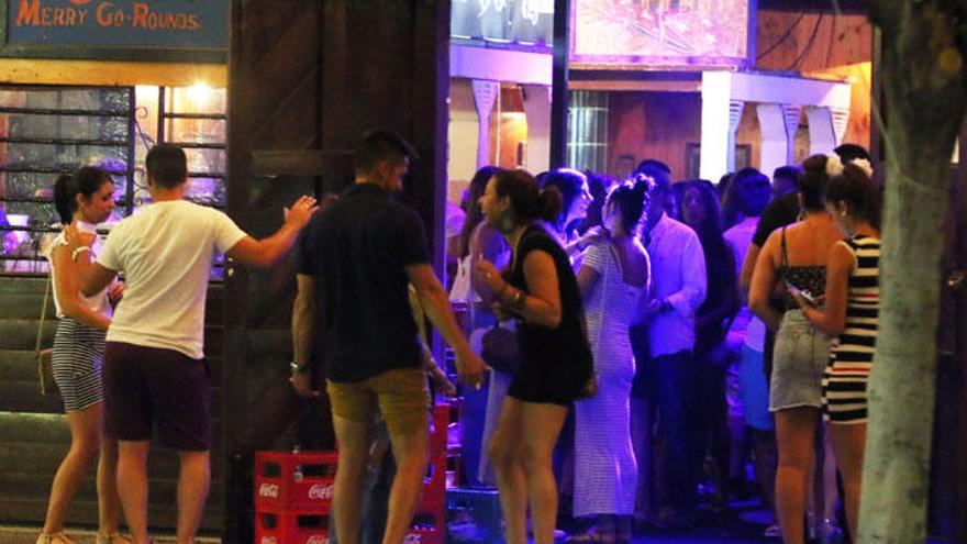 Decenas de personas junto a la puerta de una de las casetas del Real de la Feria de Málaga.