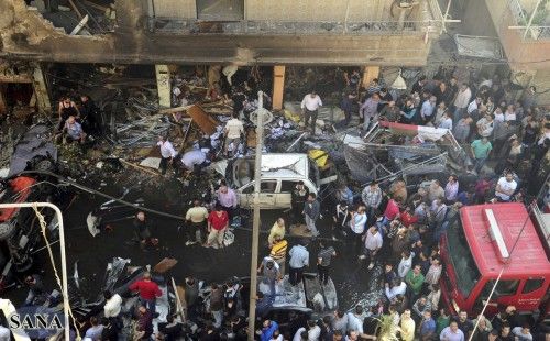 Una multitud se reúne frente a un edificio dañado después de que un coche bomba en el distrito Jaramana, cerca de Damasco, en esta fotografía folleto publicado por las autoridades nacionales de Siria agencia de noticias SANA 29 de octubre 2012.
