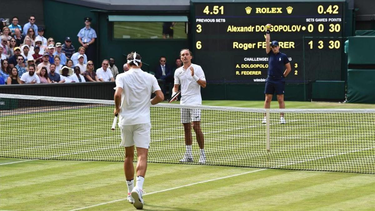 Roger Federer se dirige a la red tras el abandono de Dolgopolov