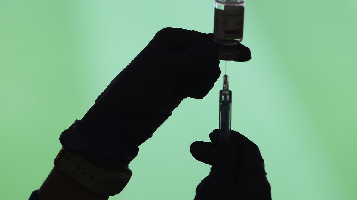 Un profesional sanitaria sostiene una jeringuilla y un vial con la vacuna del Covid-19.