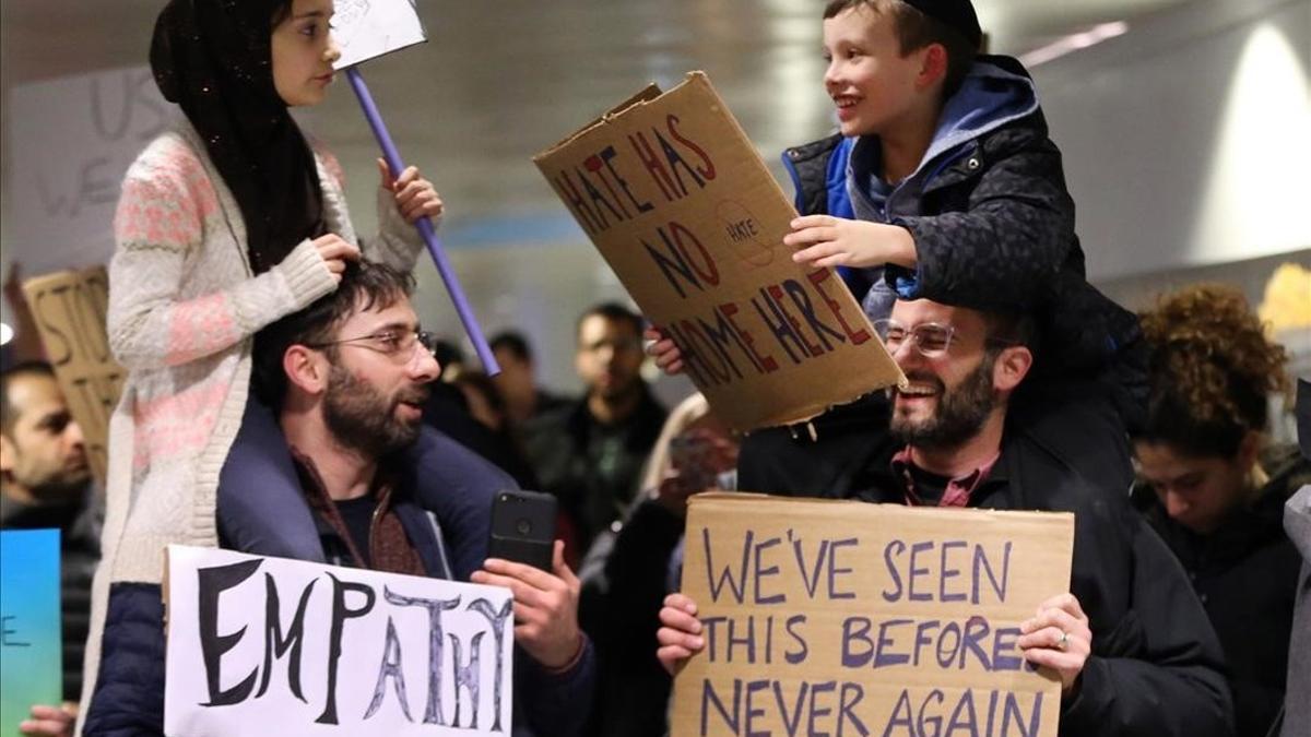 Adin y Meryem sentados sobre los hombros de sus padres, Jordan Bendant-Appell, un rabino, y Faith Yildrim, un musulmán, en una manifestación en Chicago.