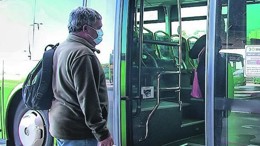 Un pasajero entra por la puerta de atrás de una guagua de Titsa.