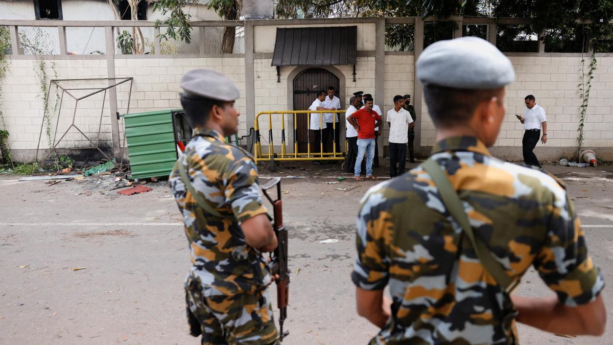 People stand next to the private residence of Sri Lanka's Prime Minister Wickremesinghe, in Colombo