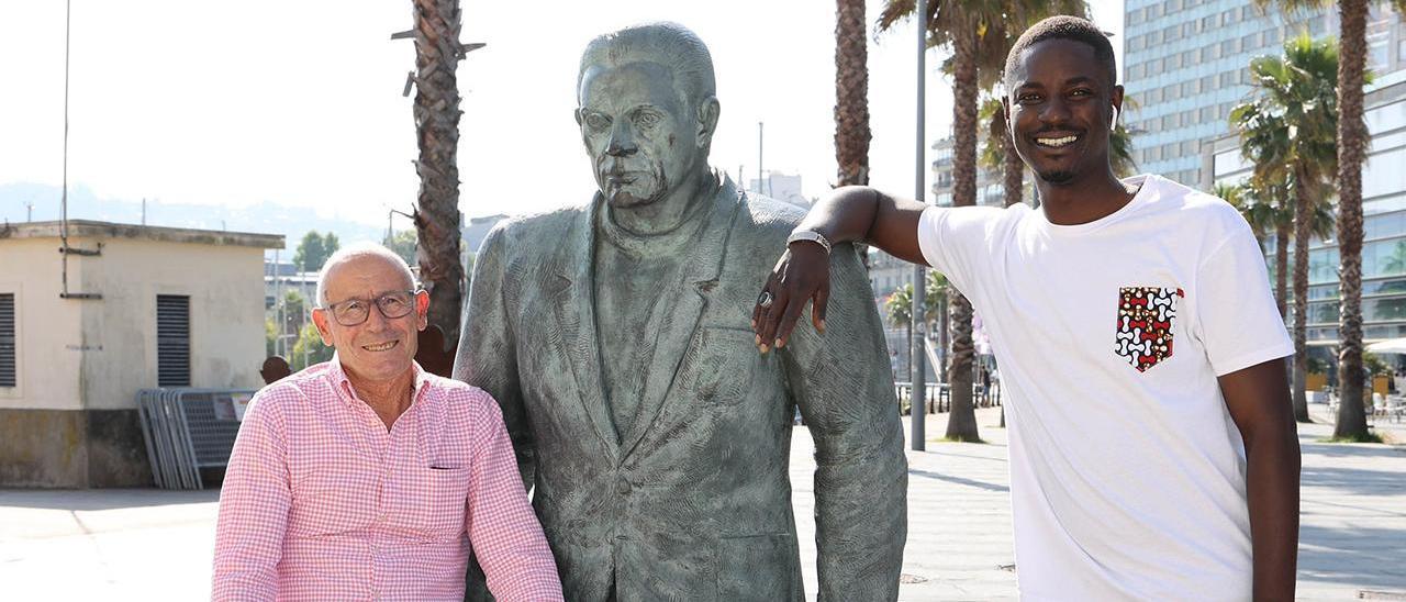 Manuel Alonso y Cheikh Seck, en el monumento al emigrante en la Estación marítima en Vigo.