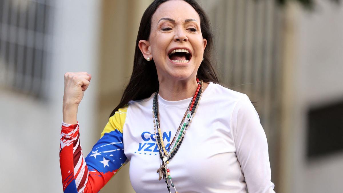 La líder opositora Maria Corina Machado, con un rosario y camiseta con los colores de la bandera venezolana.