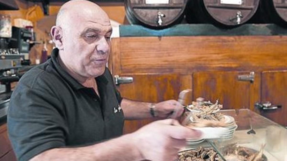 Pepe Gómez sirve unos boquerones fritos en el Bar La Plata.