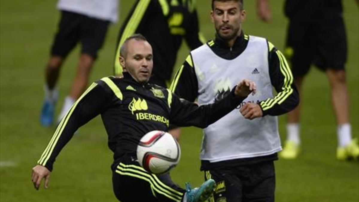 Iniesta y Piqué, ayer, durante el entrenamiento de la selección española en el Carlos Tartiere de Oviedo.