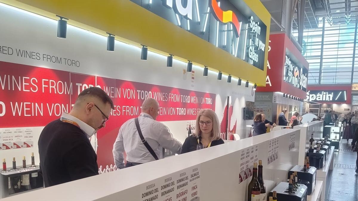 Visitantes de la feria recorren el stand en el que pueden catar vinos de la DO Toro.
