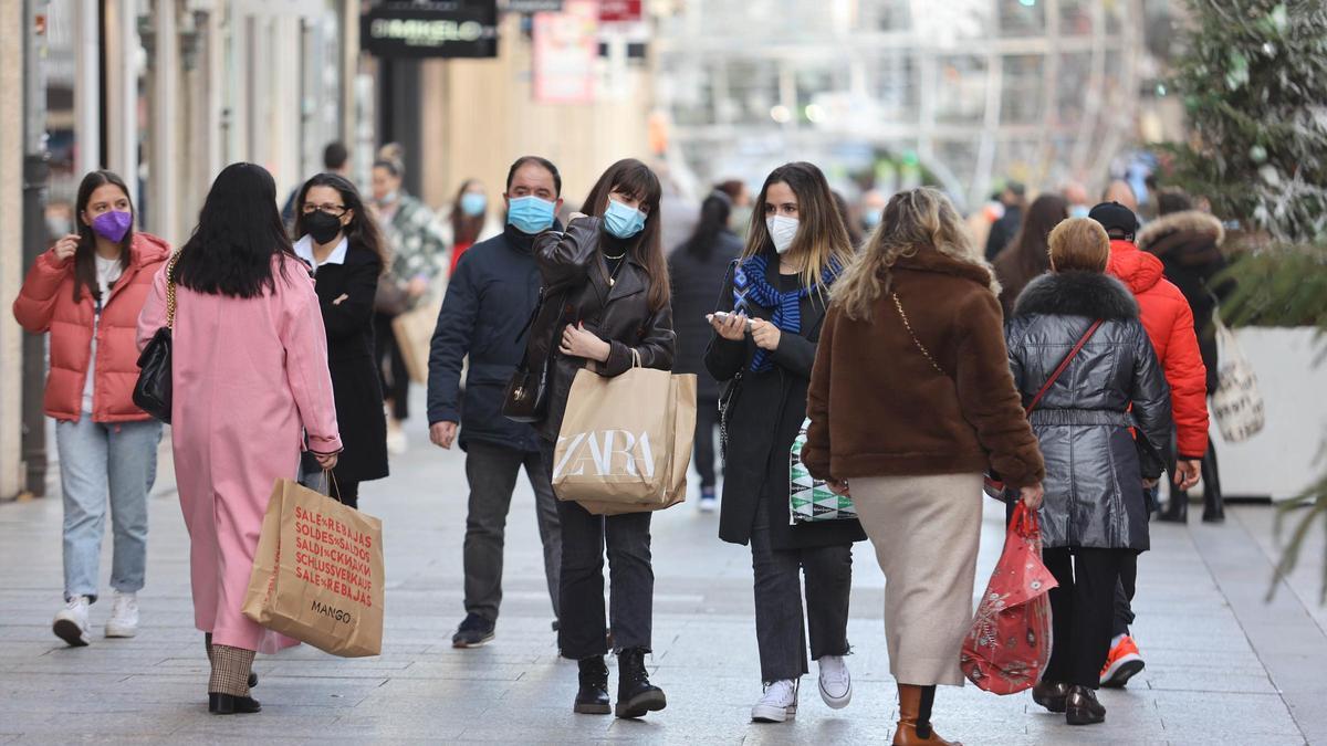 Las recién estrenadas rebajas de invierno animan a los gallegos a salir a la calle y entrar en establecimientos comerciales. En la imagen, ciudadanos caminando por la calle Príncipe, en Vigo.