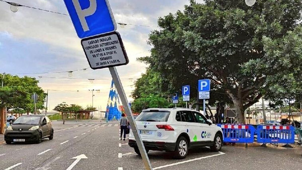 Cartel de aparcamiento reservado doblado a causa de los fuertes vientos.