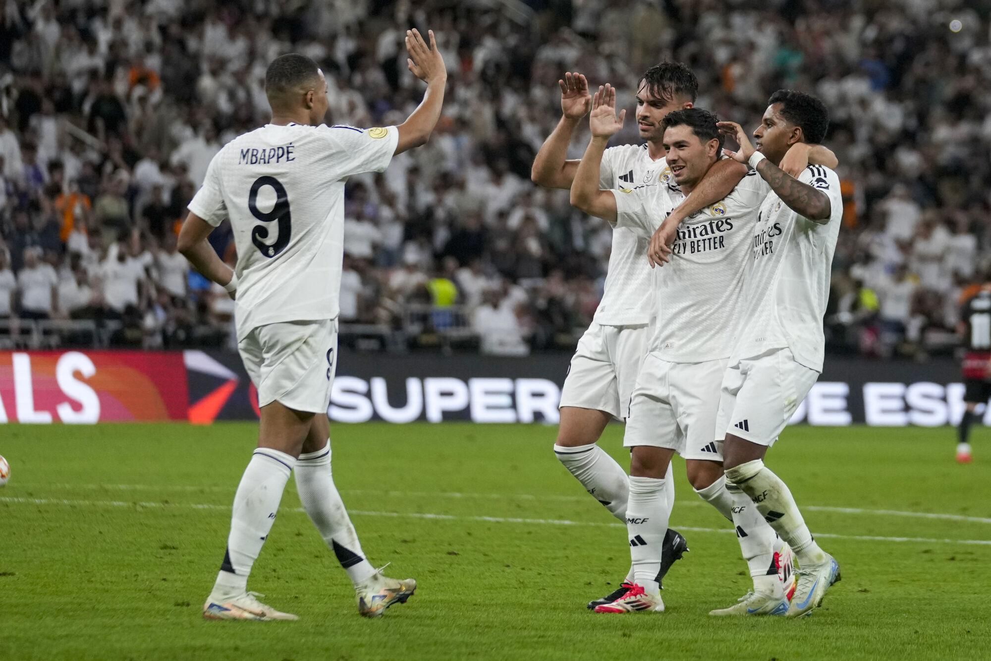Real Madrid players celebrate after Mallorca's Martin Valjent scored an own goal during the Spanish Super Cup semifinal soccer match between Real Madrid and Mallorca at the King Abdullah Stadium in Jeddah, Saudi Arabia, Thursday, Jan. 9, 2025. (AP Photo/Altaf Qadri)