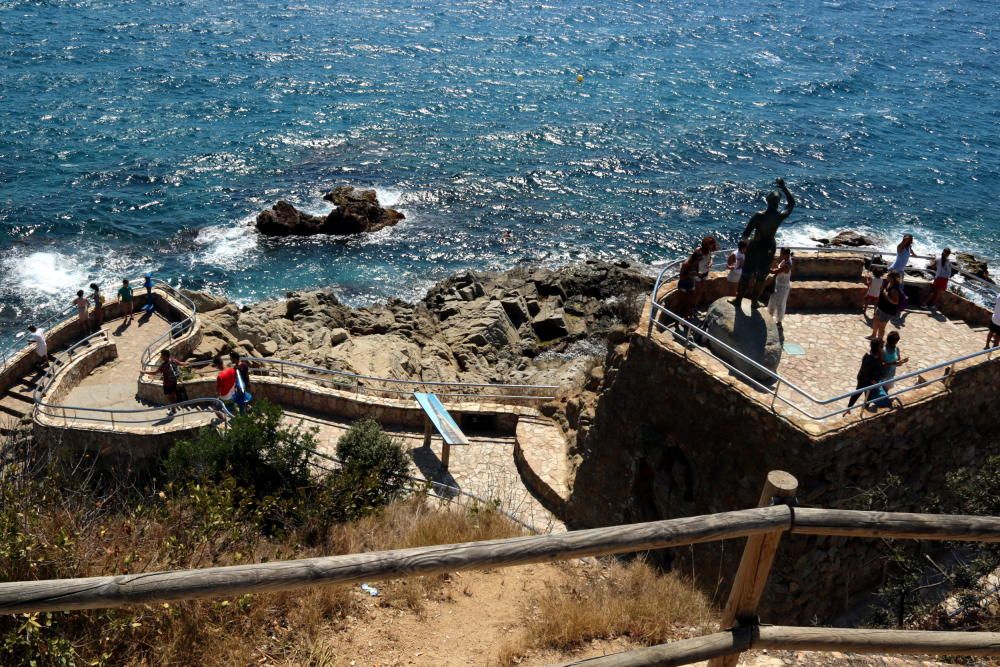 Lloc des d'on el turista hauria saltat des del mirador fins abaix del camí de ronda. En primer pla, la tanca de fusta que hauria saltat.