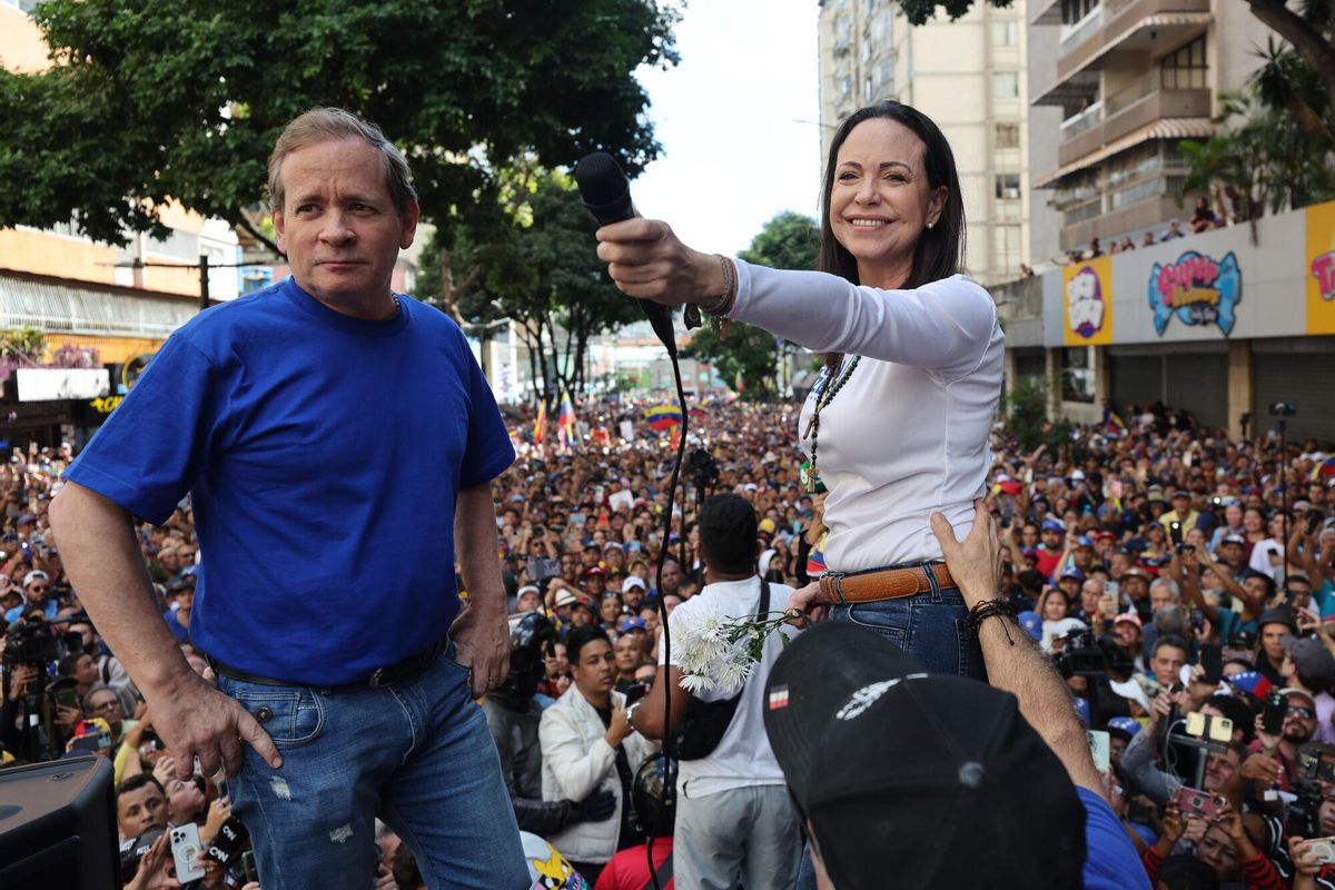 AME9799. CARACAS (VENEZUELA), 09/01/2025.- La líder antichavista María Corina Machado (d) saluda a sus seguidores junto al exdiputado venezolano Juan Pablo Guanipa este jueves, en una manifestación en Caracas (Venezuela). Machado anunció, a un día de la toma de posesión presidencial, el comienzo de una nueva fase del proceso para la libertad de Venezuela, y pidió a los ciudadanos estar atentos a las señales sobre los próximos pasos. EFE/ Miguel Gutiérrez