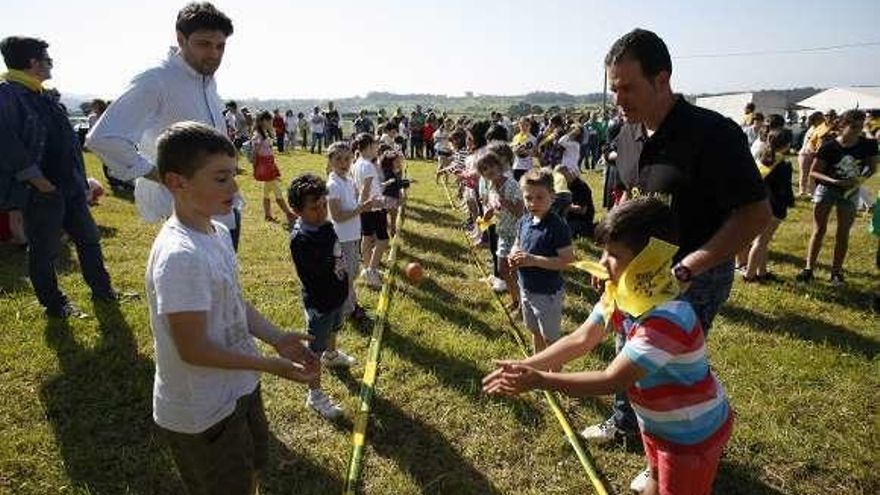 Varios niños juegan al lanzamiento del huevo en el prau de la fiesta.