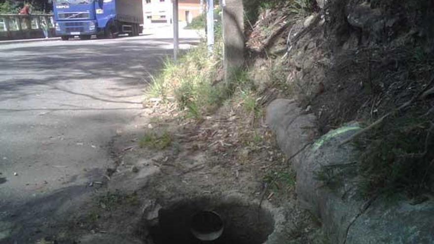 Una de las alcantarillas, sin la tapa, en la curva de A Cerradiña, en Domaio.