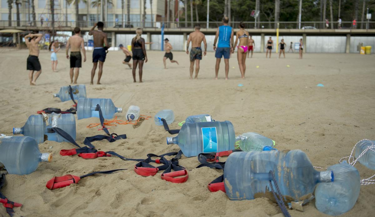 Los bidones de agua de 8 litros, material básico del entrenamiento en la playa 