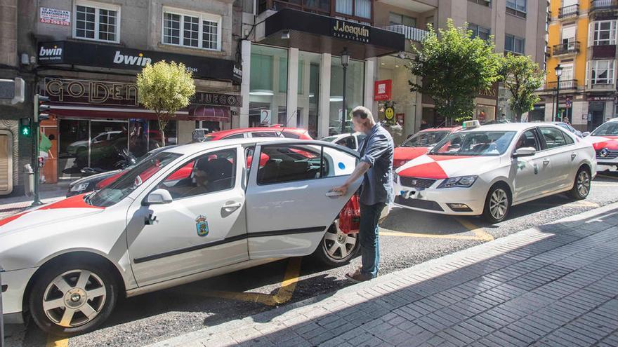 Un cliente coge un taxi en una parada de Vigo // C. Graña