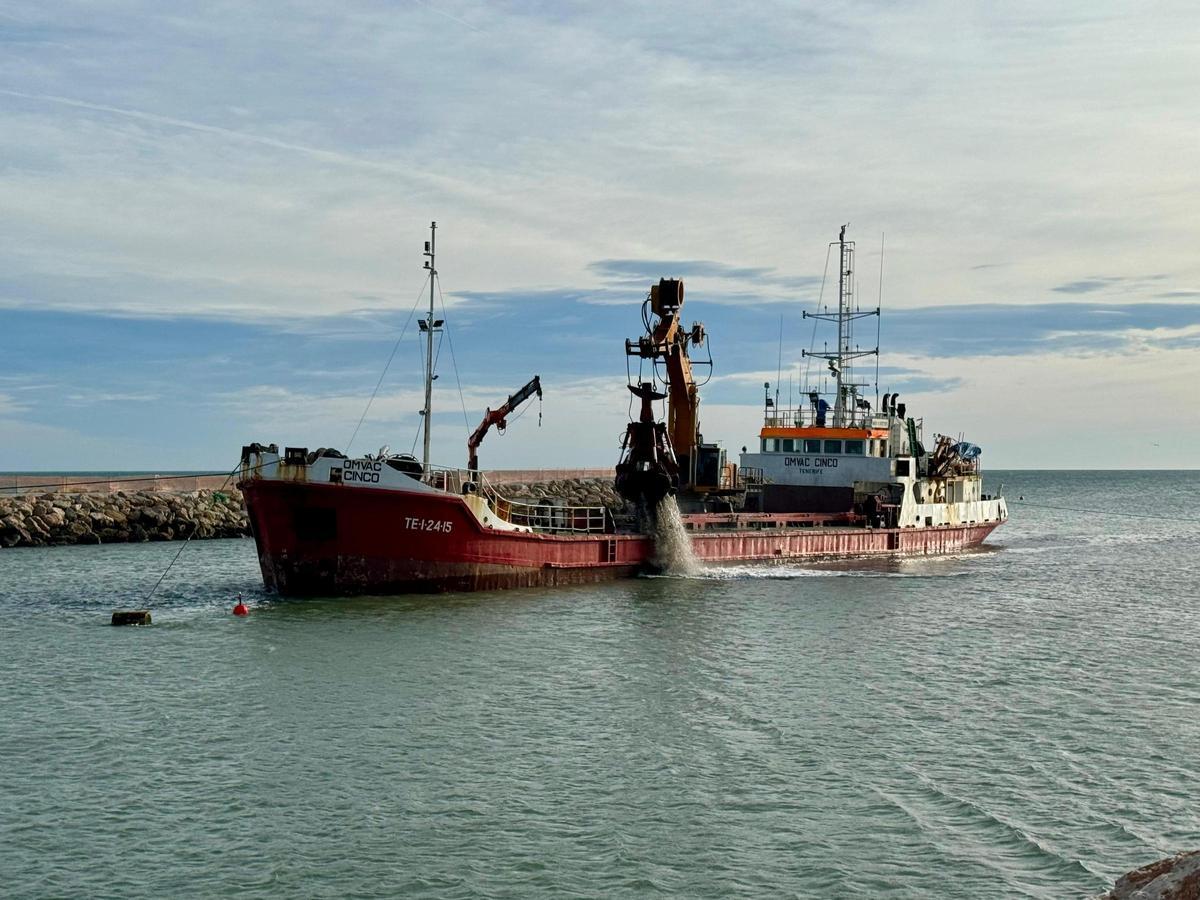 El barco que saca la arena del fondo del cauce en el puerto de Cullera.