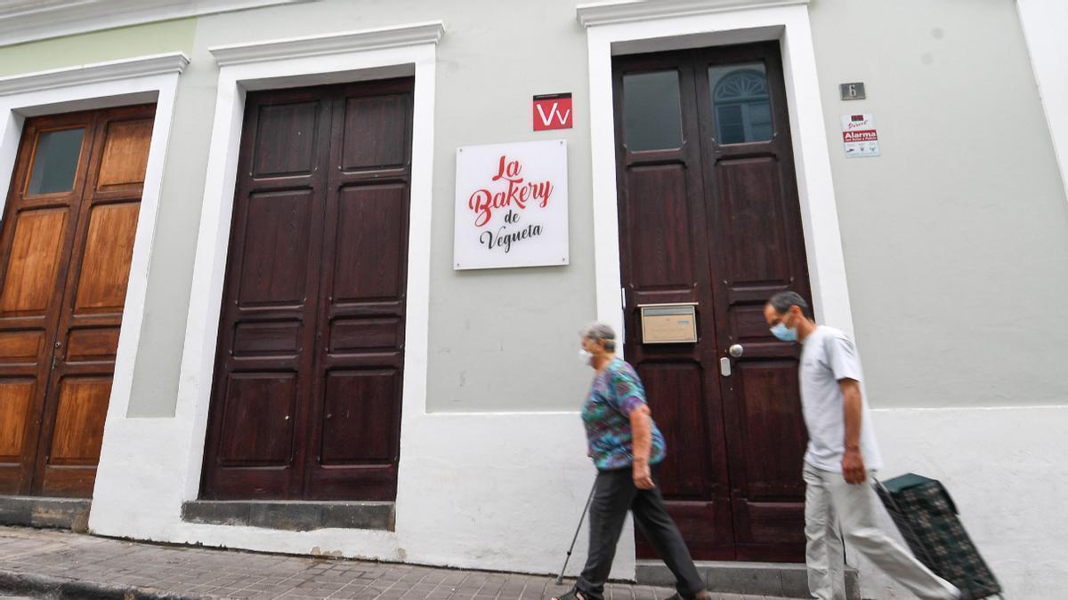 Dos personas pasan junto a una vivienda vacacional del barrio de Vegueta de la capital grancanaria.