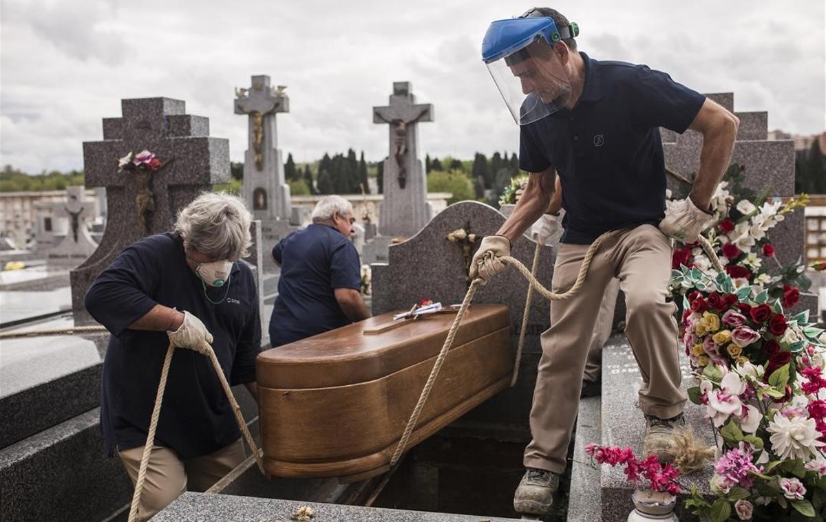Enterradores bajan el ataúd de Manuela Revuelta en el cementerio de La Almudena, en Madrid, el 7 de abril del 2020. Manuela falleció el 4 de abril a consecuencia del covid-19 a la edad de 94 años en una residencia de ancianos.