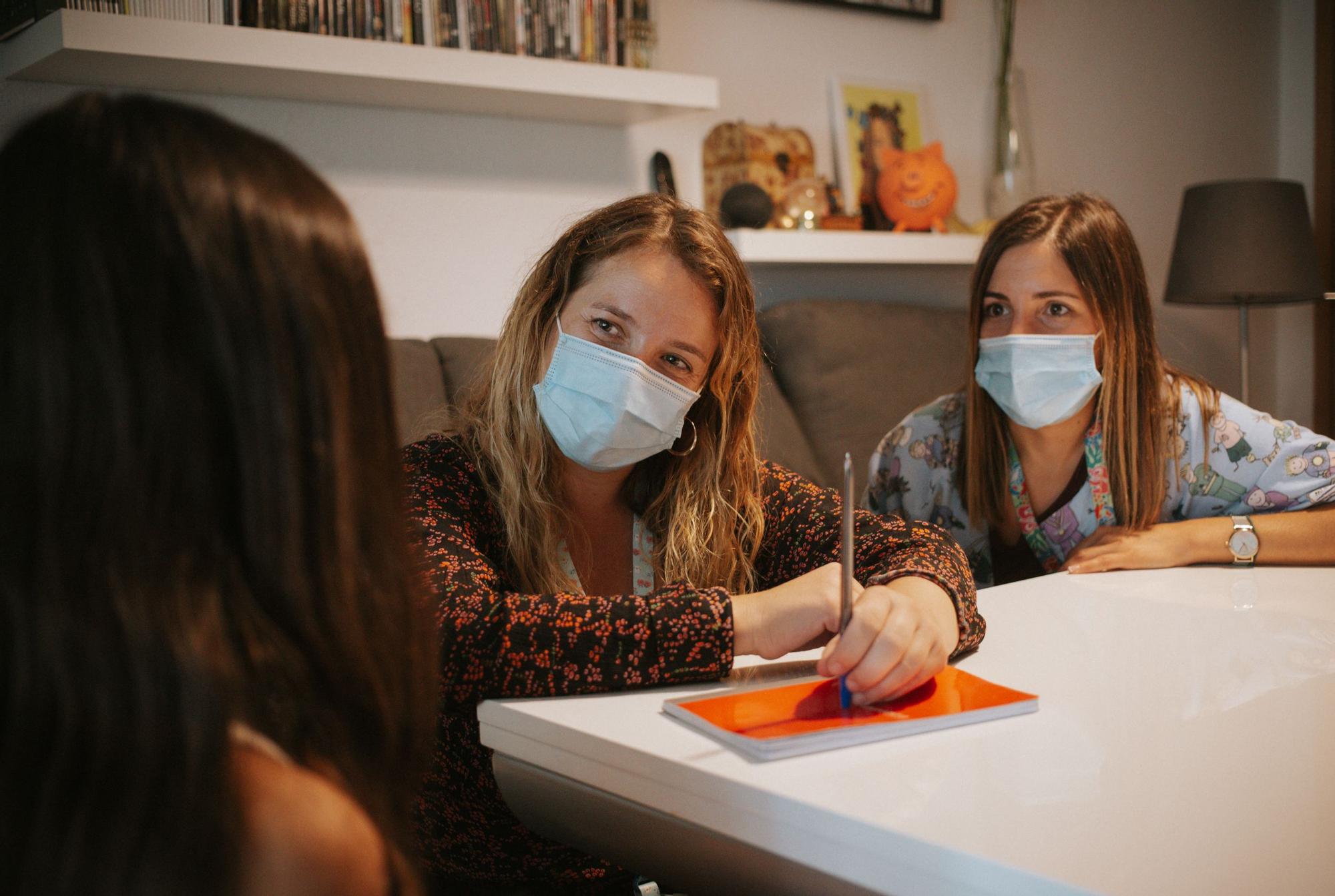 La psiquiatra Goretti Morón y la enfermera Cristina García con Aitana en su casa.