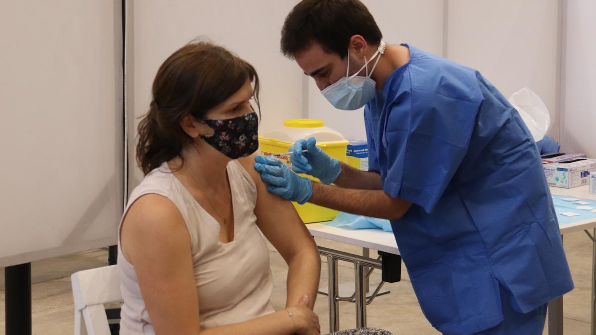 Pla mig d&#039;un infermer administrant una vacuna contra la covid-19 a una dona al palau firal de Girona