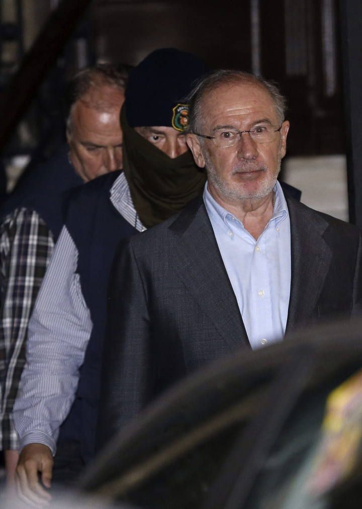 El exvicepresidente del Gobierno Rodrigo Rato (d) abandona su despacho cuatro horas después de que comenzara el registro por parte de los agentes de la Agencia Tributaria y de Aduanas, que han sacado una veintena de cajas con documentación.