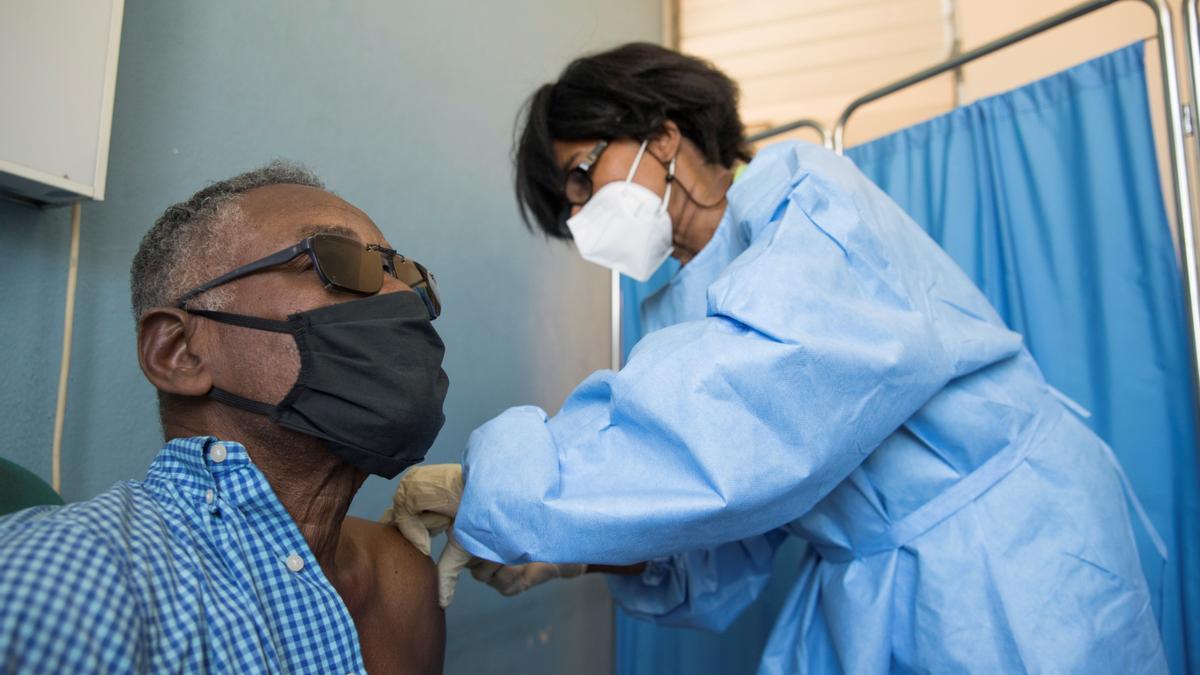 Una enfermera vacuna a un hombre en Haití, el país acaba de recibir el primer lote de dosis anticovid.
