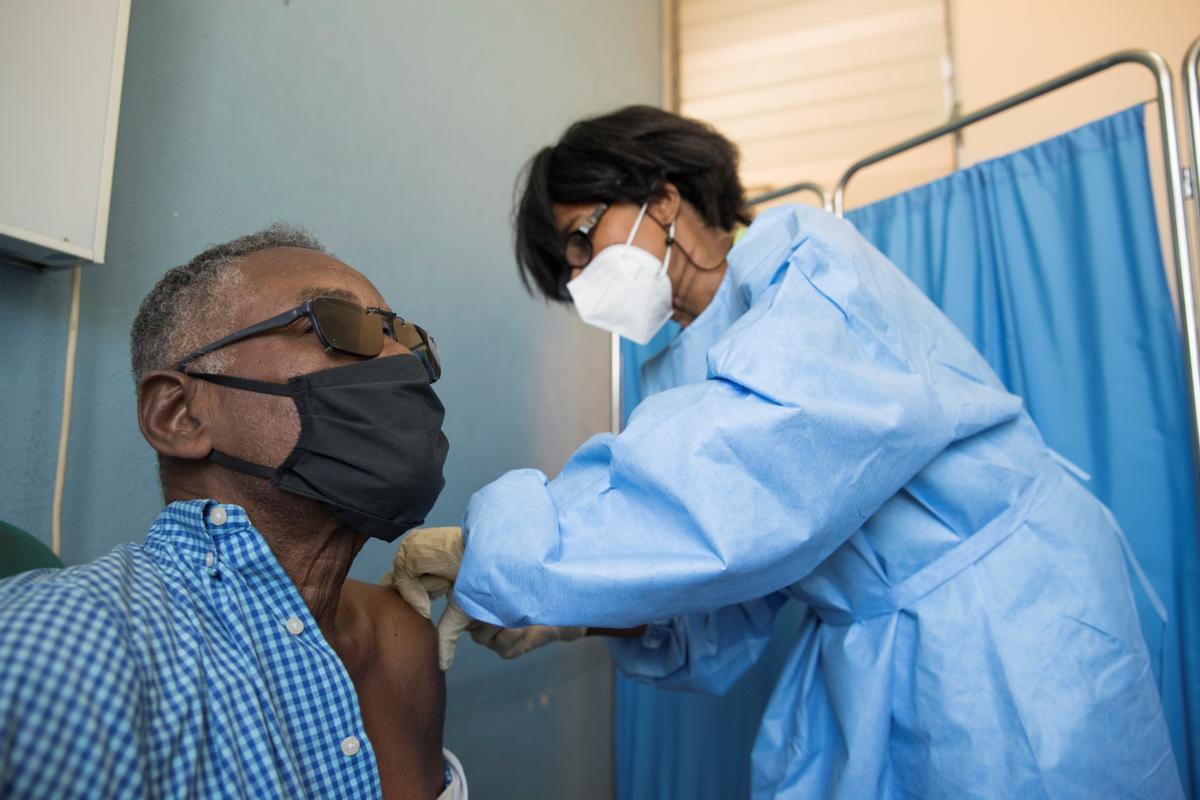 Una enfermera vacuna a un hombre en Haití, el país acaba de recibir el primer lote de dosis anticovid.