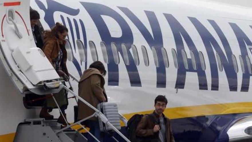 Viatgers de Ryanair sortint de l&#039;avió amb maletes.