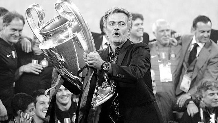 Mourinho sujeta el trofeo de la Liga de Campeones, con los jugadores y auxiliares del Inter detrás.