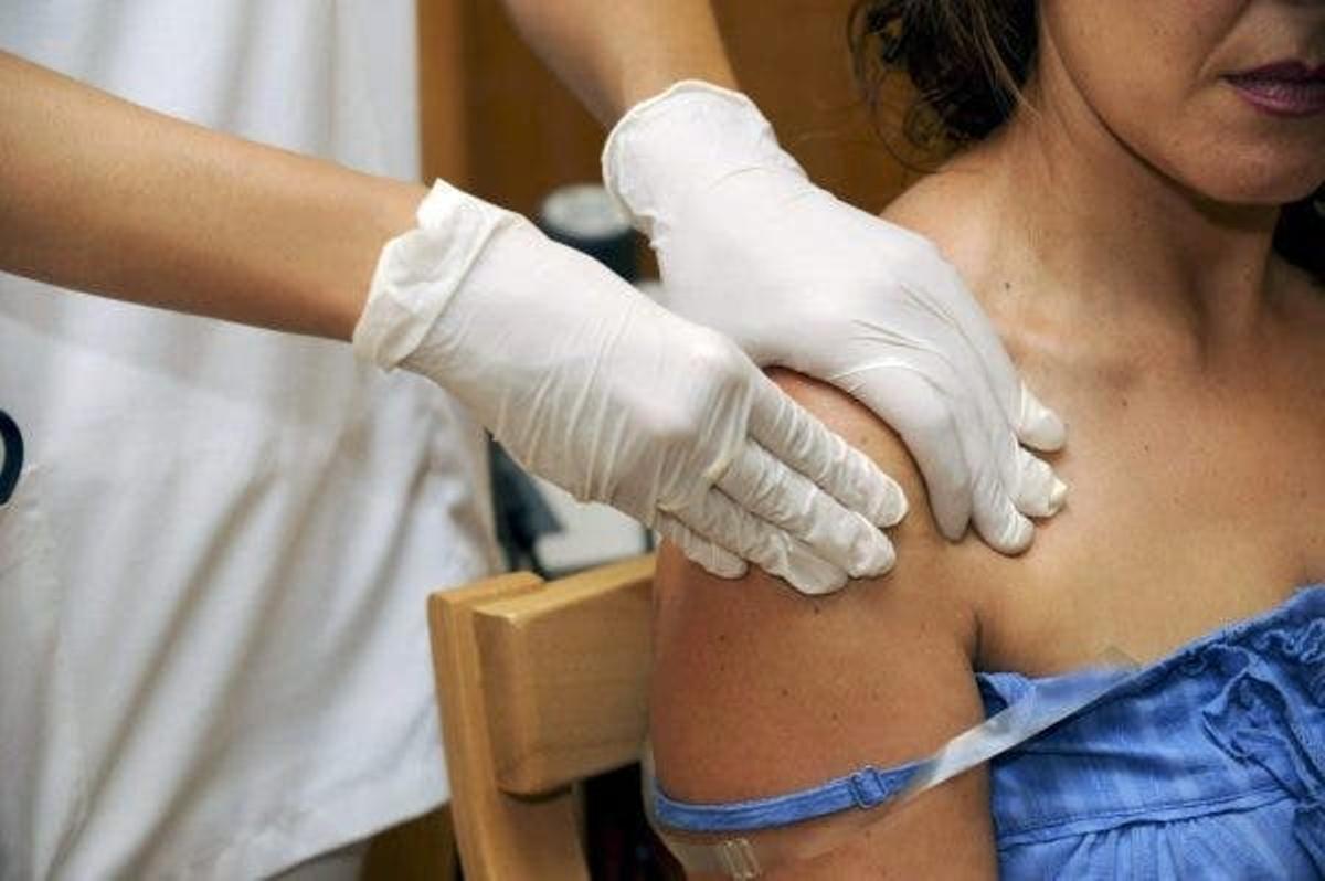 Un fisoterapeuta comprueba el estado del hombro de una paciente.