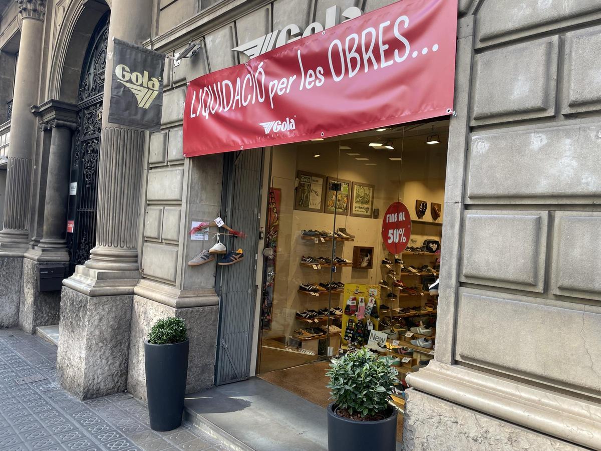 Tienda Gola en la calle Muntaner, con un cartel de liquidación por las obras de la L8