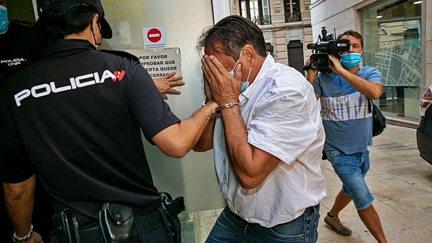 El acusado se tapa la cara al llegar a la Audiencia de Alicante. | RAFA ARJONES