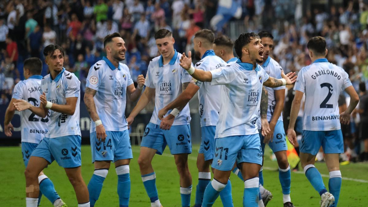 Los jugadores del Málaga CF celebran el gol de Kevin que ha dado la victoria al equipo frente al San Fernando.